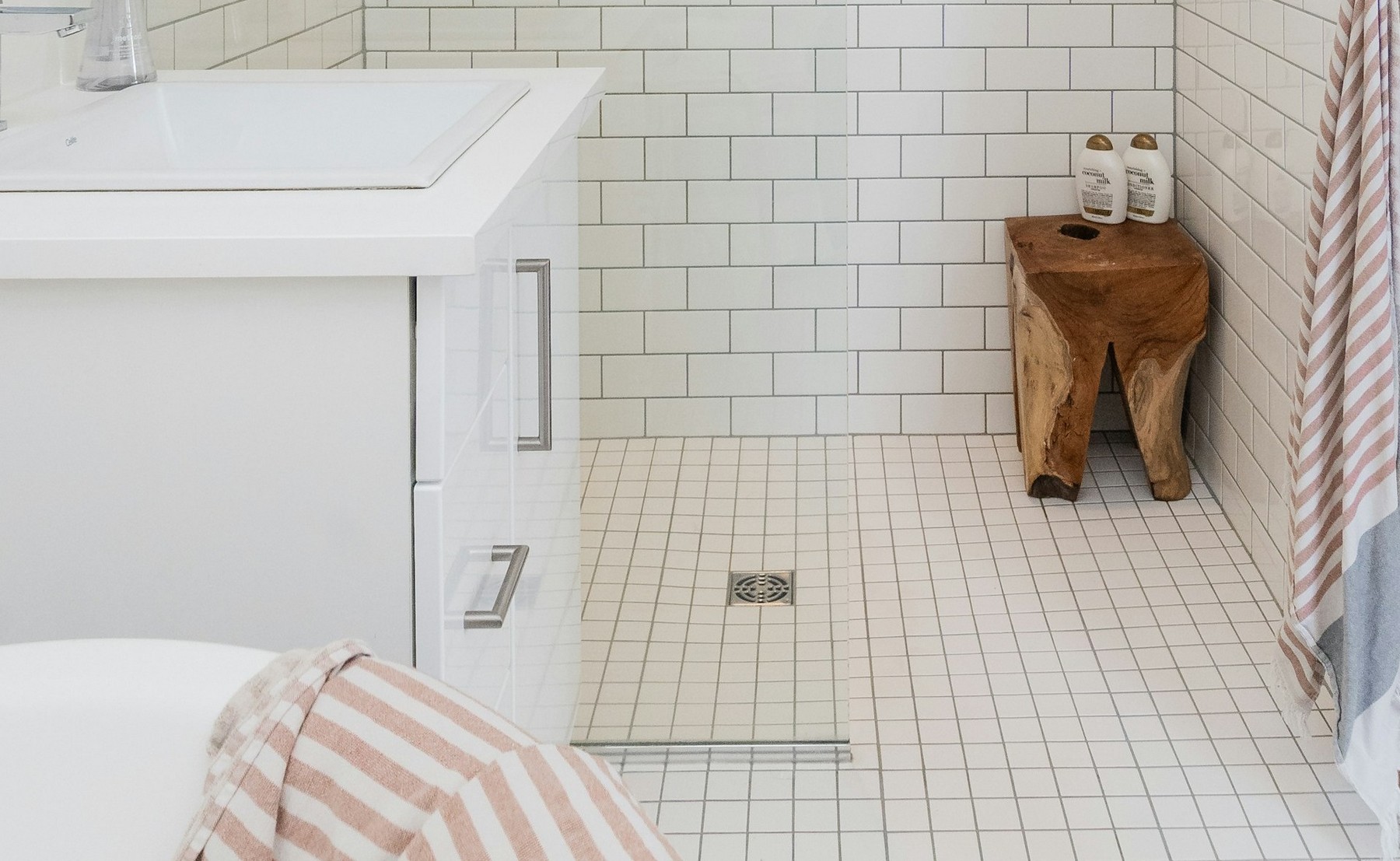 Pömpel neben einem Duschabfluss im Badezimmer